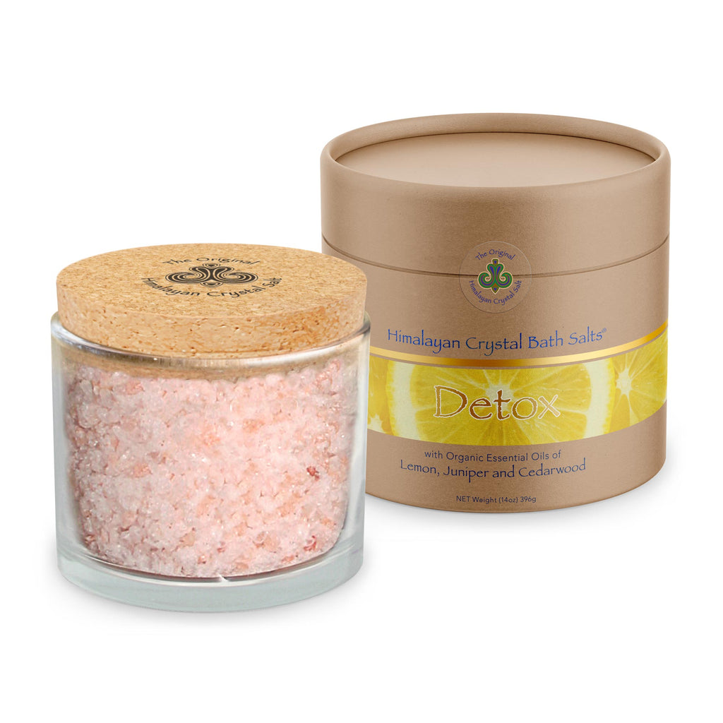 Detox Bath Salts product glass jar filled with Himalayan Crystal Salt stones with salts, cork cover and tan product box with bands of gold and sliced lemons  both featuring Himalayan Crystal Salt logo, on white background