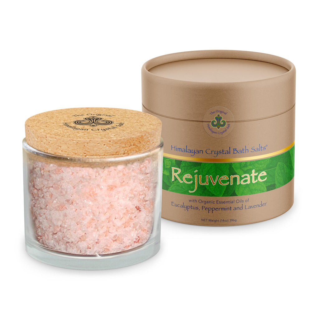 Rejuvenate Bath Salts product glass jar filled with Himalayan Crystal Salt, cork cover and tan product box with bands of gold and green leaves both featuring Himalayan Crystal Salt logo, on white background