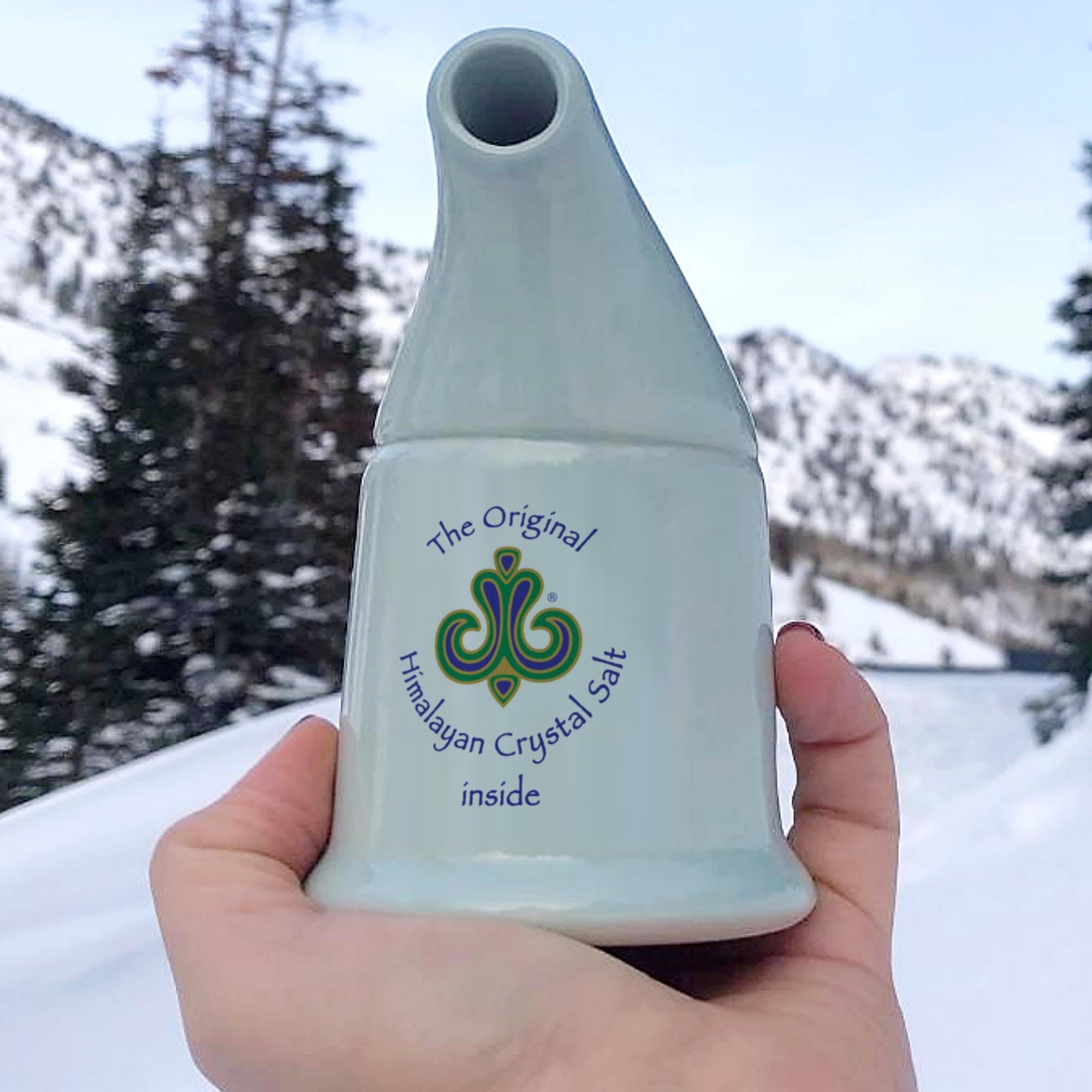 Inhaler + Neti Pot off-white ceramic inhaler in white hand, with snow, trees and mountains in background