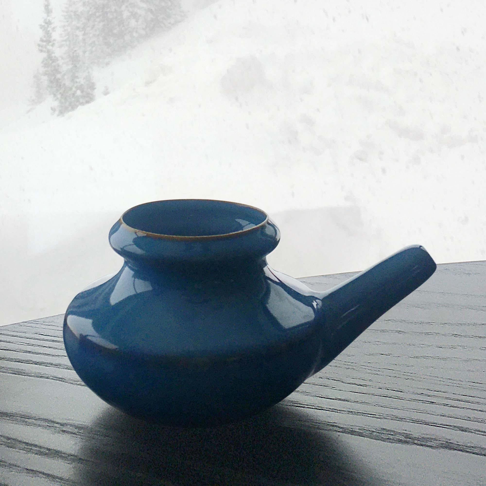 Dusk Blue Neti Pot ceramic blue with brown accents on table with snowy background