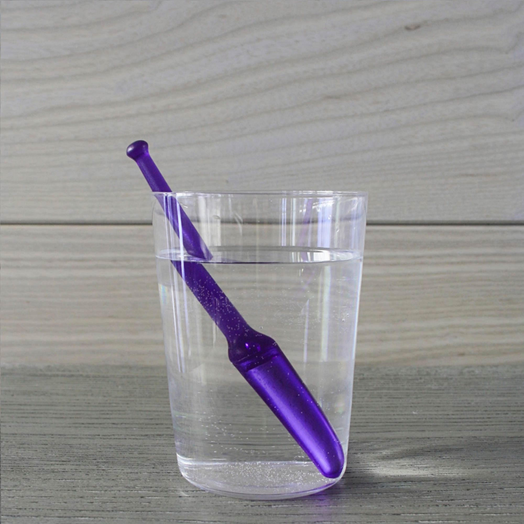 Zen Master StirWand purple stirwand in glass filled with water, on wood surface